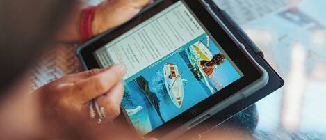 A tablet displaying a nautical-themed image with boats and a sea horse.