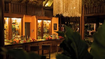 A bar area with wooden furniture and a hanging light fixture.
