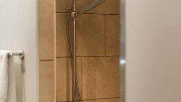 Eine Dusche mit Handbrause und Wandarmatur.