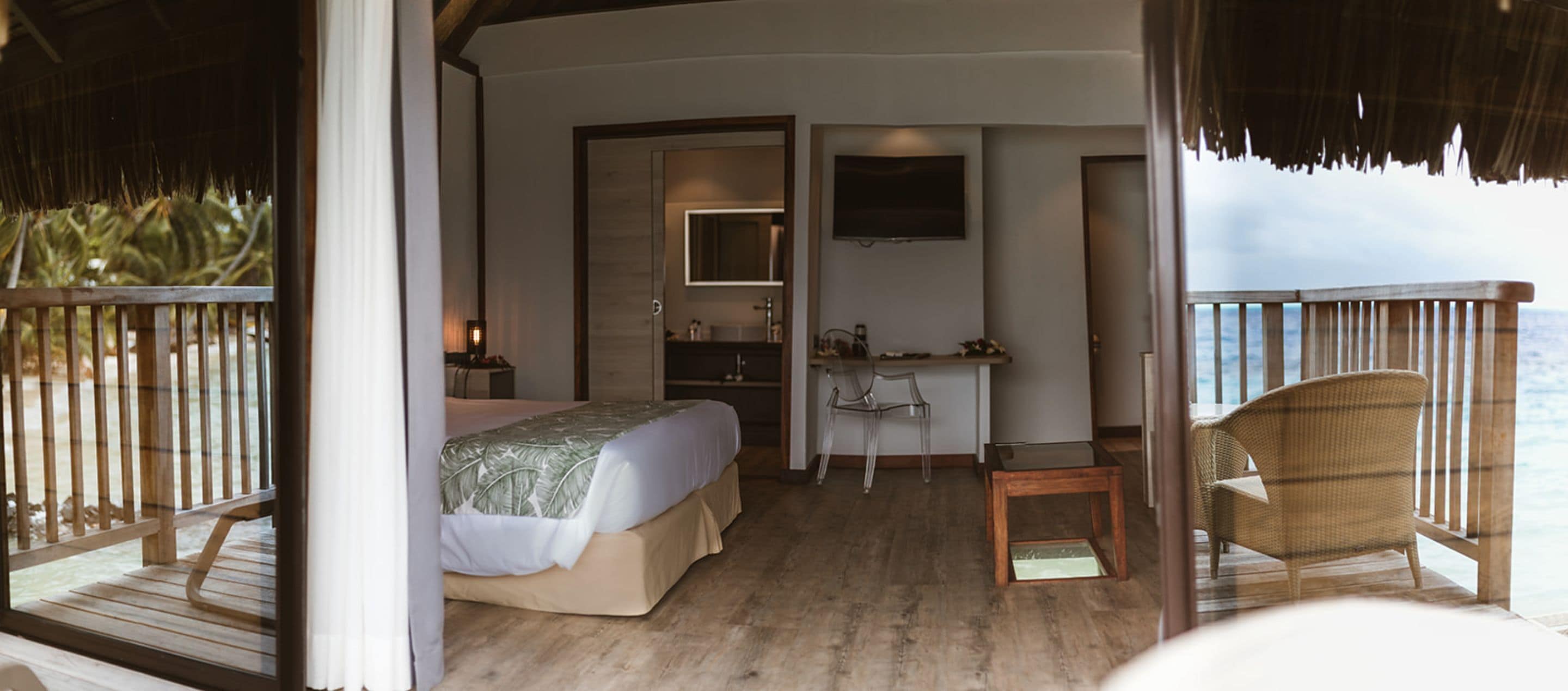 Ein Schlafzimmer mit einem Bett, einem Schreibtisch, einem Sessel und einem Fernseher.