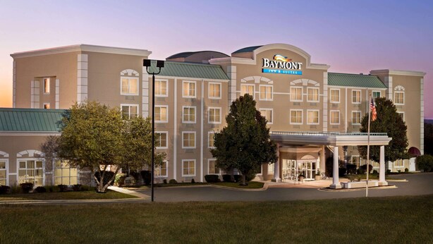Un hotel grande de varios pisos con un letrero destacado que dice "Baymont Inn & Suites".
