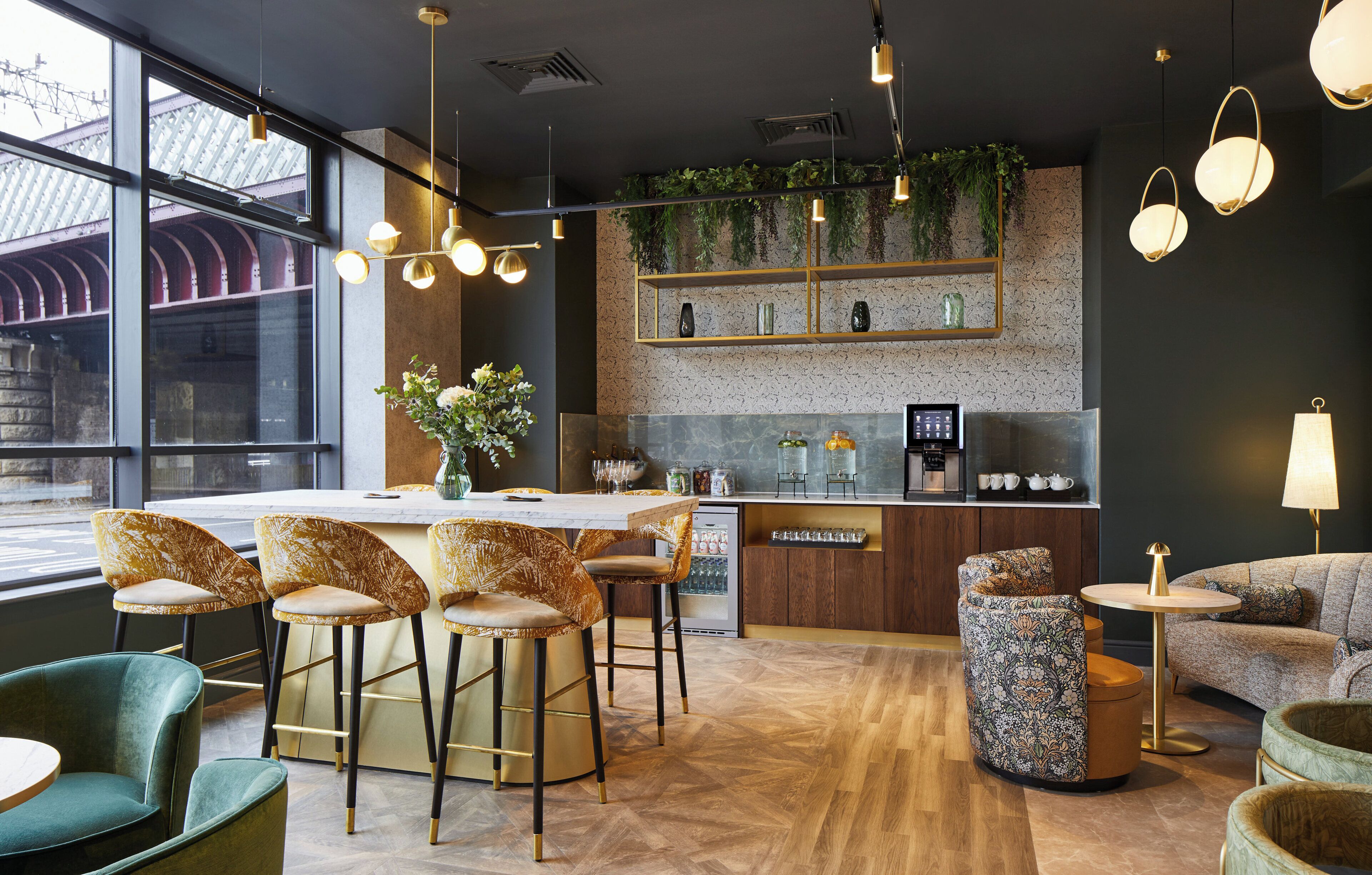 Eine moderne Bar mit einer Marmorplatte, Barhocker und verschiedenen Gläsern.