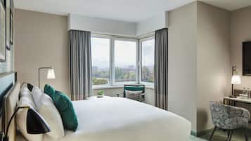 Een hotelkamer met een groot bed, een bureau, een stoel en een raam met uitzicht op de stad.