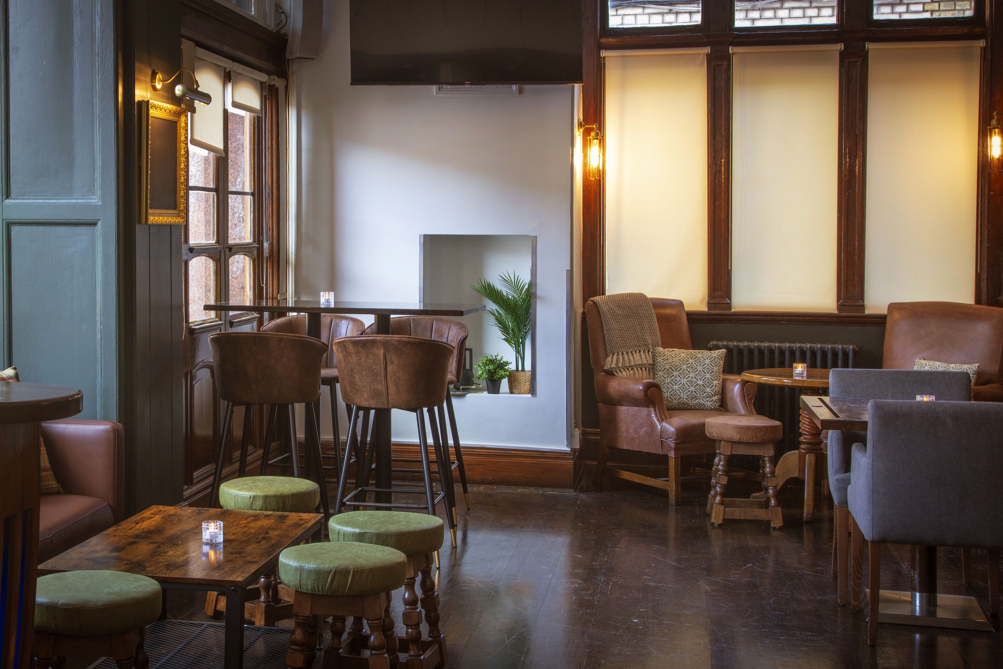 A cozy restaurant interior with wooden furniture, a fireplace, and a large window.