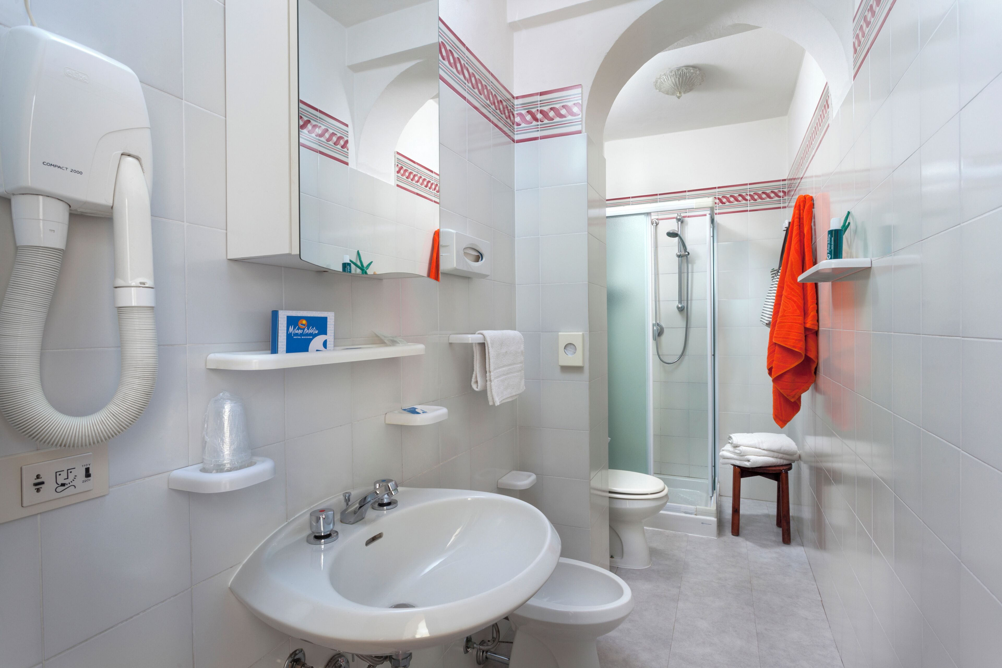 A modern bathroom with a sink, toilet, and shower.