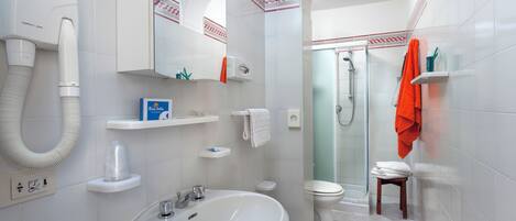 A modern bathroom with a sink, toilet, and shower.