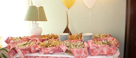 Una mesa de buffet con diversos alimentos y globos.