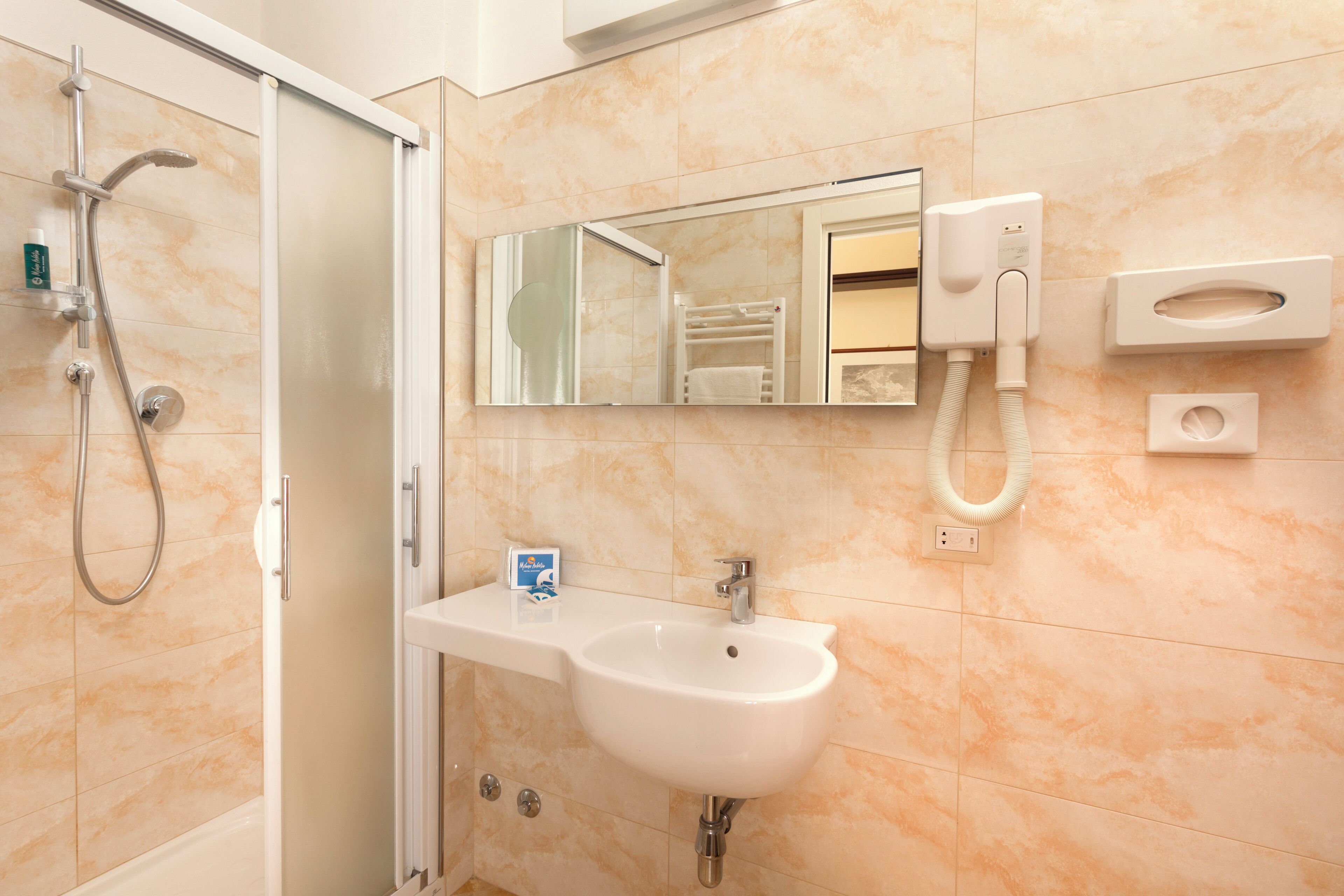 A bathroom with a shower, sink, mirror, towel rack, and a hand dryer.