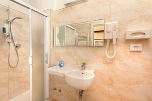 A bathroom with a shower, sink, mirror, and towel rack. - Milano & Helvetia (Riccione)