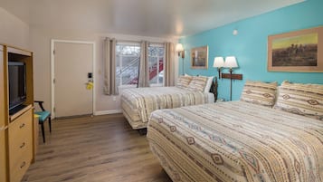 Un dormitorio con dos camas, televisión y ventana con cortinas.