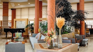 A spacious lobby with a grand piano, comfortable seating, and a decorative centerpiece.