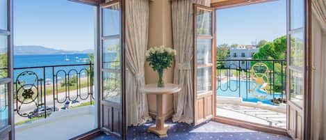 A balcony with a view of the sea and a pool.