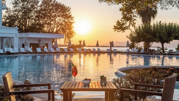 Ein Poolbereich mit Liegestühlen und einem Tisch mit Getränken und einer Obstschale.