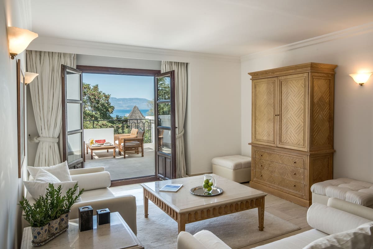 Ein modernes Wohnzimmer mit einem großen Holzschrank, einer Couch, einem Couchtisch und Blick ins Freie.