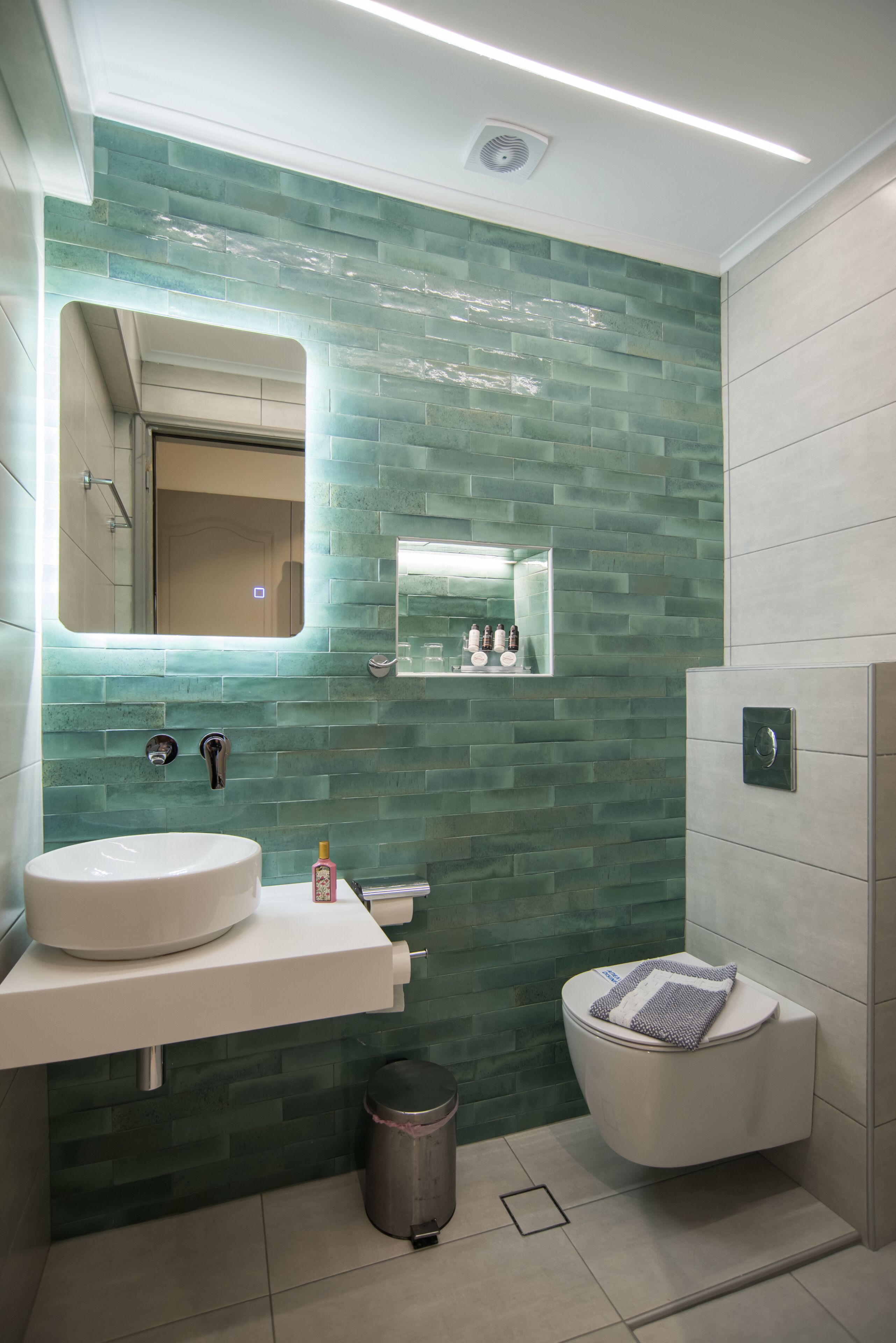 A bathroom with a white sink, a mirror, and a toilet.