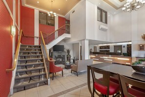 Un interior espacioso con escalera, chimenea, comedor y cocina.