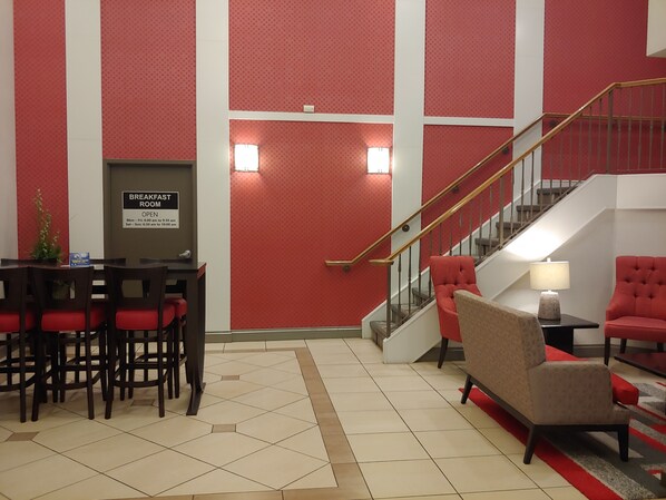 A breakfast room with a sign indicating it is open from 6:00 am to 10:00 am, Monday to Sunday.