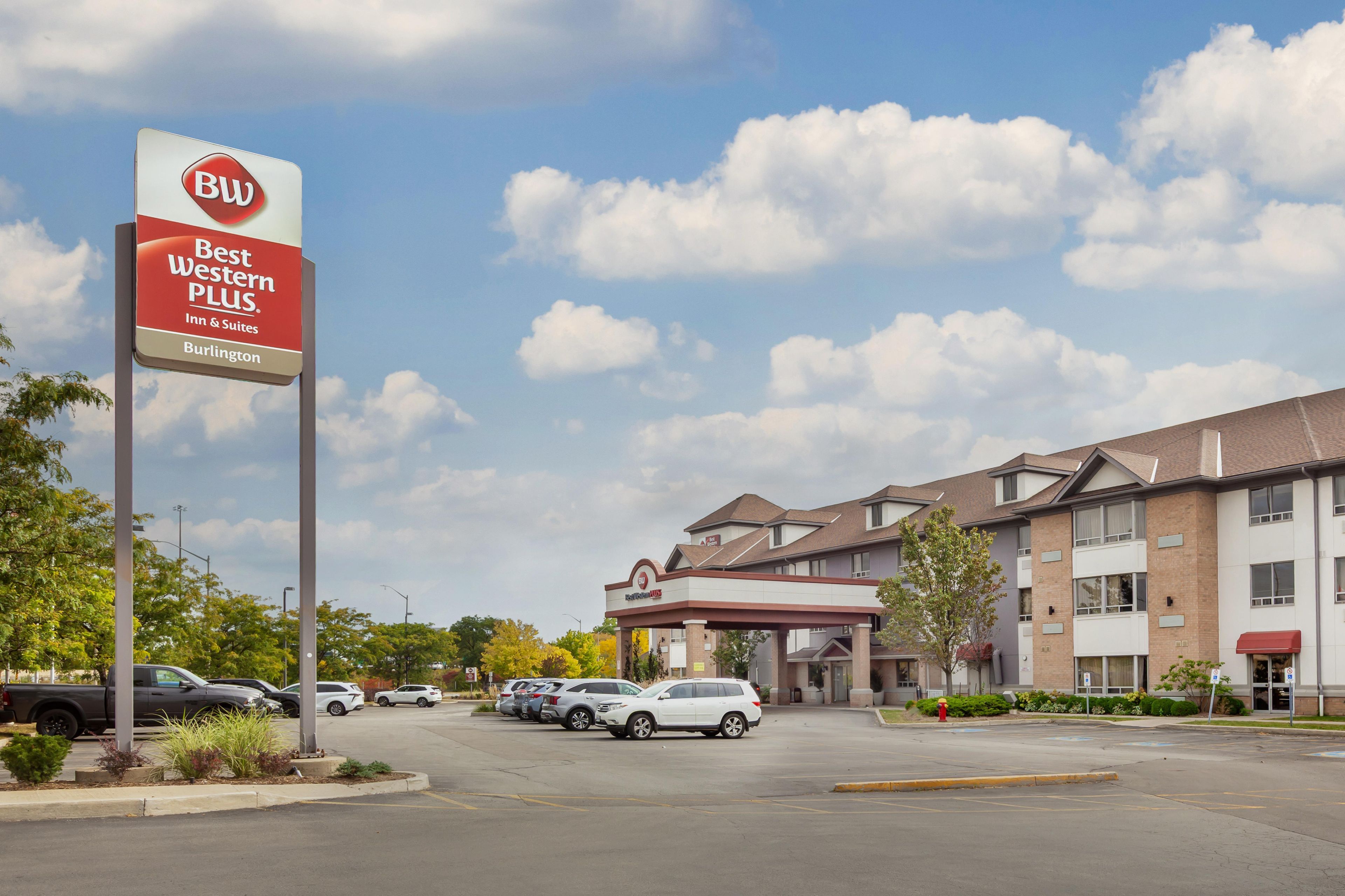 Ein Best Western Plus Hotel mit Parkplatz und mehreren Autos.