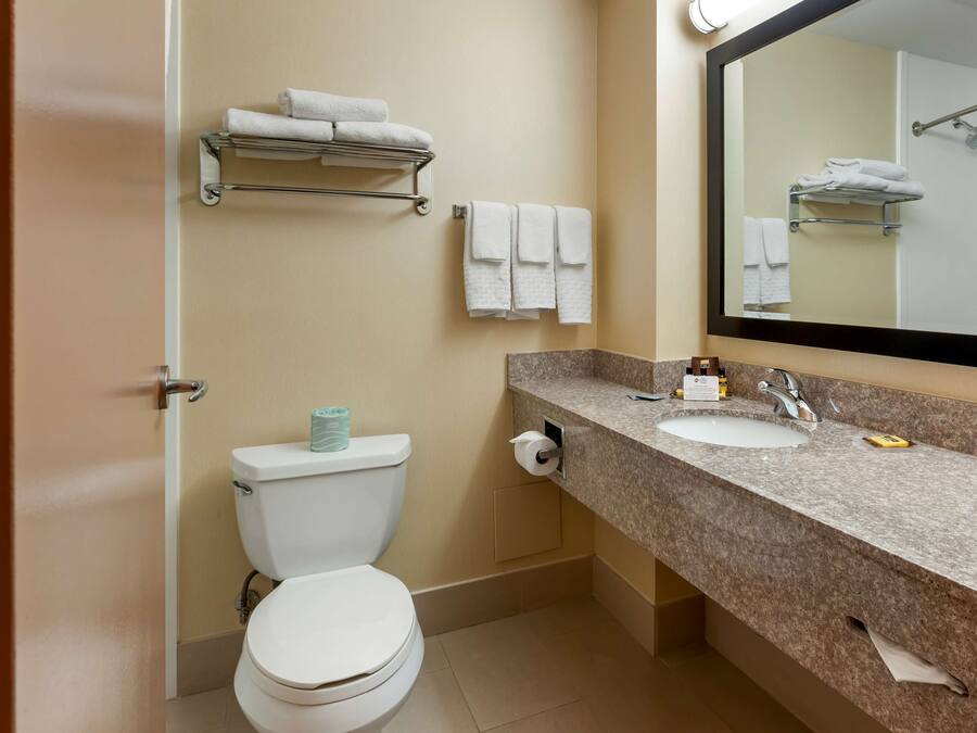 A modern bathroom with a toilet, sink, and towel rack.