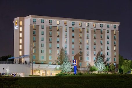 A multi-story hotel with a prominent Comfort Inn sign, a covered entrance, and a well-lit facade.