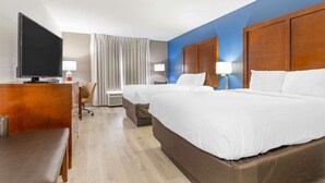 A hotel room with two beds, a desk with a TV, a chair, and a lamp. - Comfort Inn Near Six Flags St. Louis (Pacific)