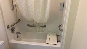 Bañera estándar con ducha, barras de apoyo y un cabezal de ducha manual.