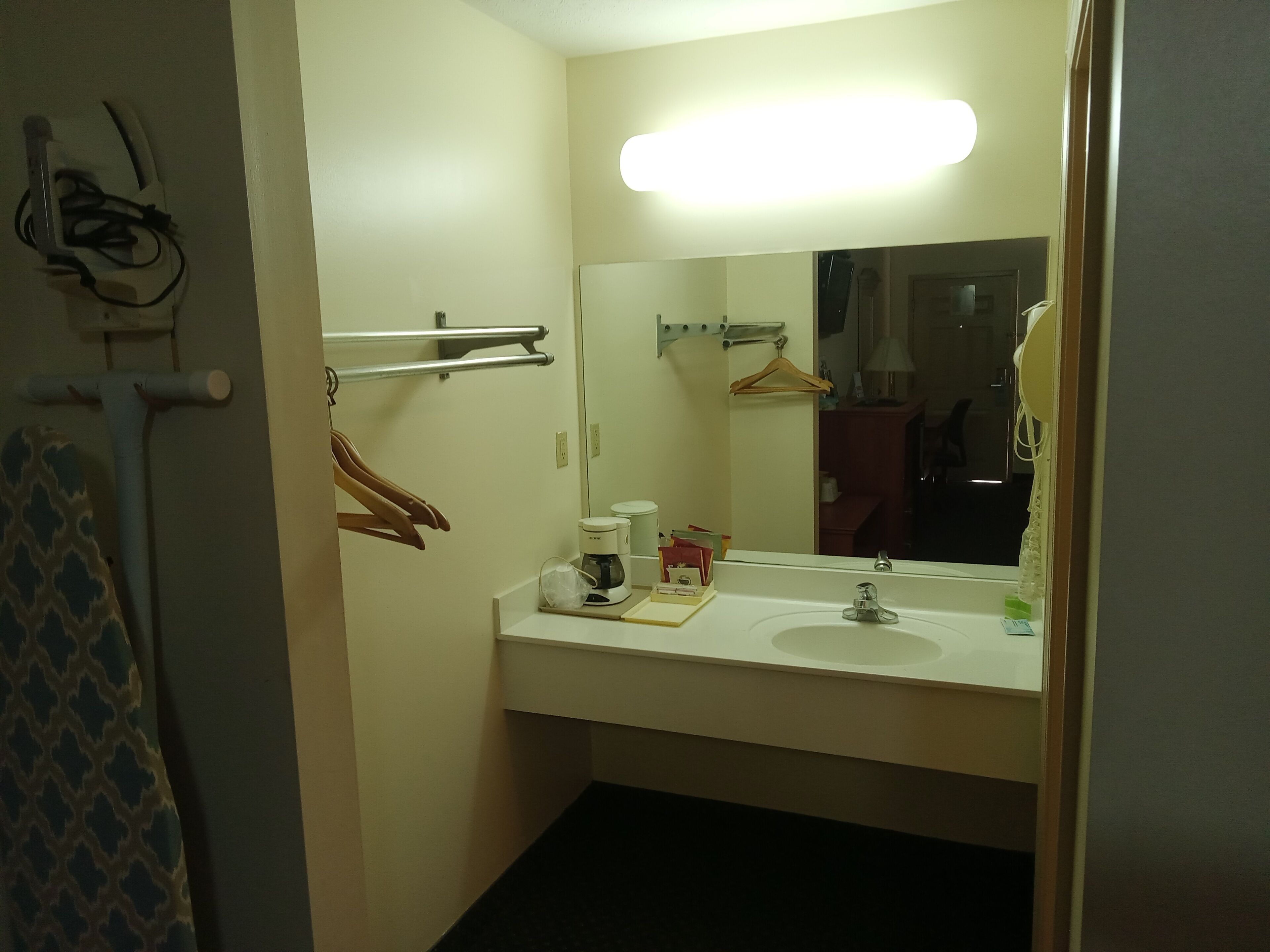 Un bagno con lavandino bianco, uno specchio e un portascopevoli.