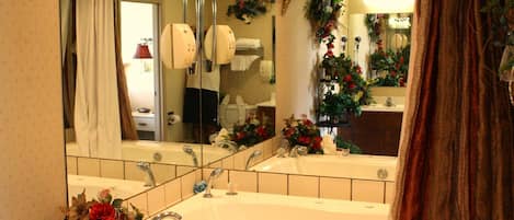 Une salle de bain avec un grand miroir, une baignoire et un rideau de douche.
