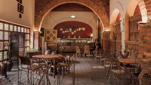Un restaurant avec des arches en briques, des tables et des chaises en bois.