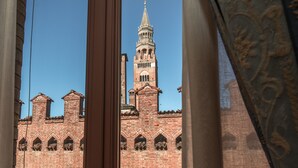 A view of a historic brick building with a prominent tower and arched windows. - Hotel Impero (Cremona)