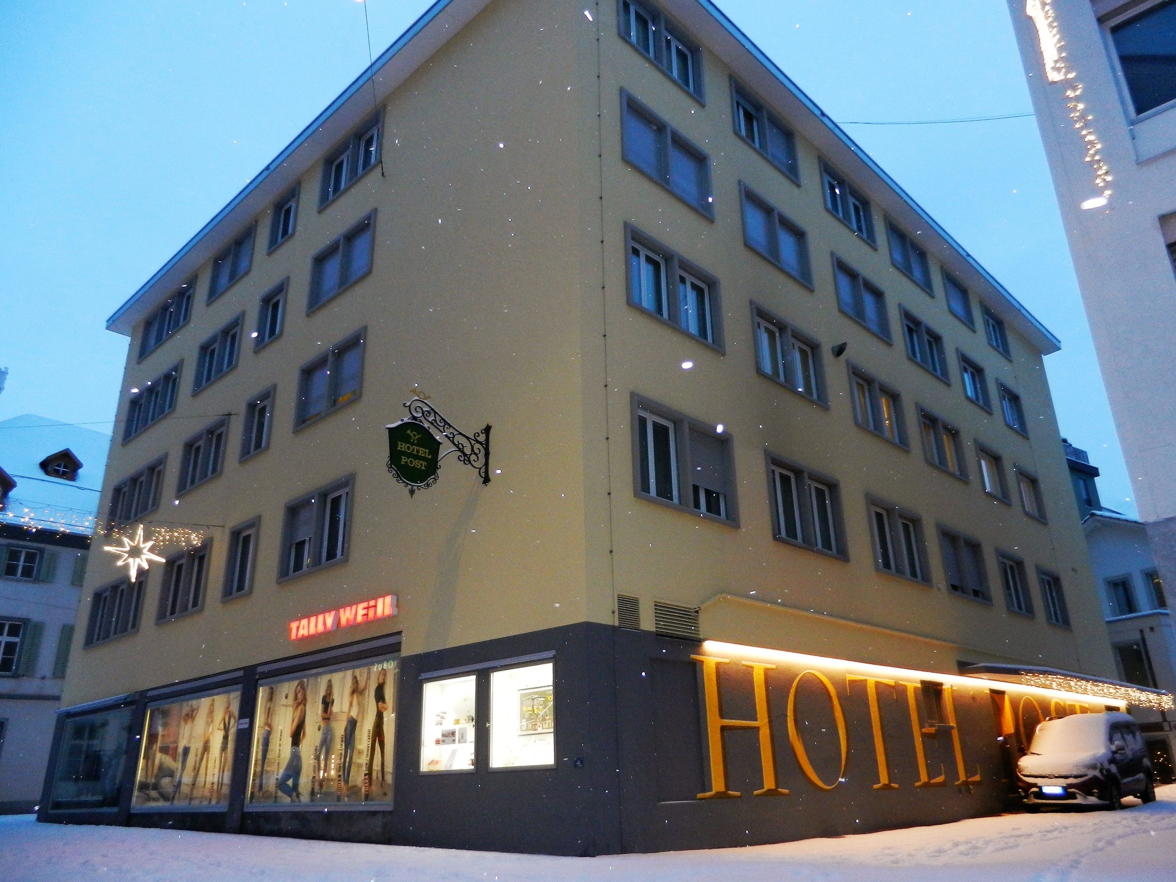 A hotel with a sign reading "HOTEL POST" and "HOTEL WEIL".