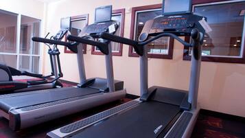 Three treadmills in a gym with digital displays and a FlexDeck Shock Absorption System.