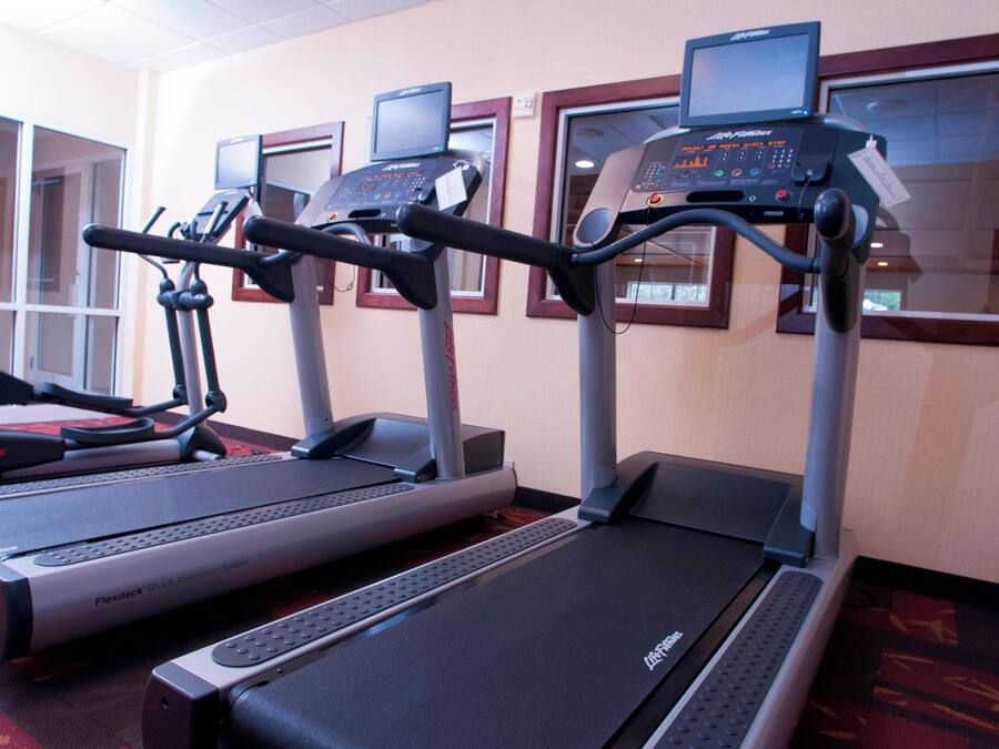 Three treadmills in a gym with digital displays and a FlexDeck Shock Absorption System.