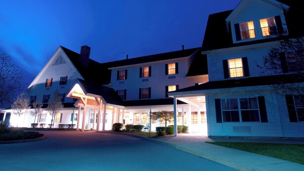 Ein großes, mehrstöckiges Hotel mit überdachter Eingangszone und zahlreichen Fenstern.