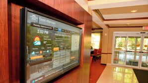 Ein digitales Display in der Hotelhalle, das lokale Wetter und Nachrichten anzeigt.