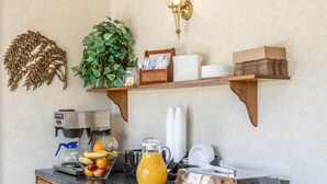 Cuina amb cafetera, motlle de fruita, gerra i safata de pastissos.