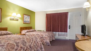 A hotel room with two beds, a television, a window with red curtains, and a painting on the wall.