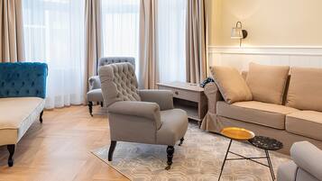 A modern living room with a sofa, armchair, and a small table.