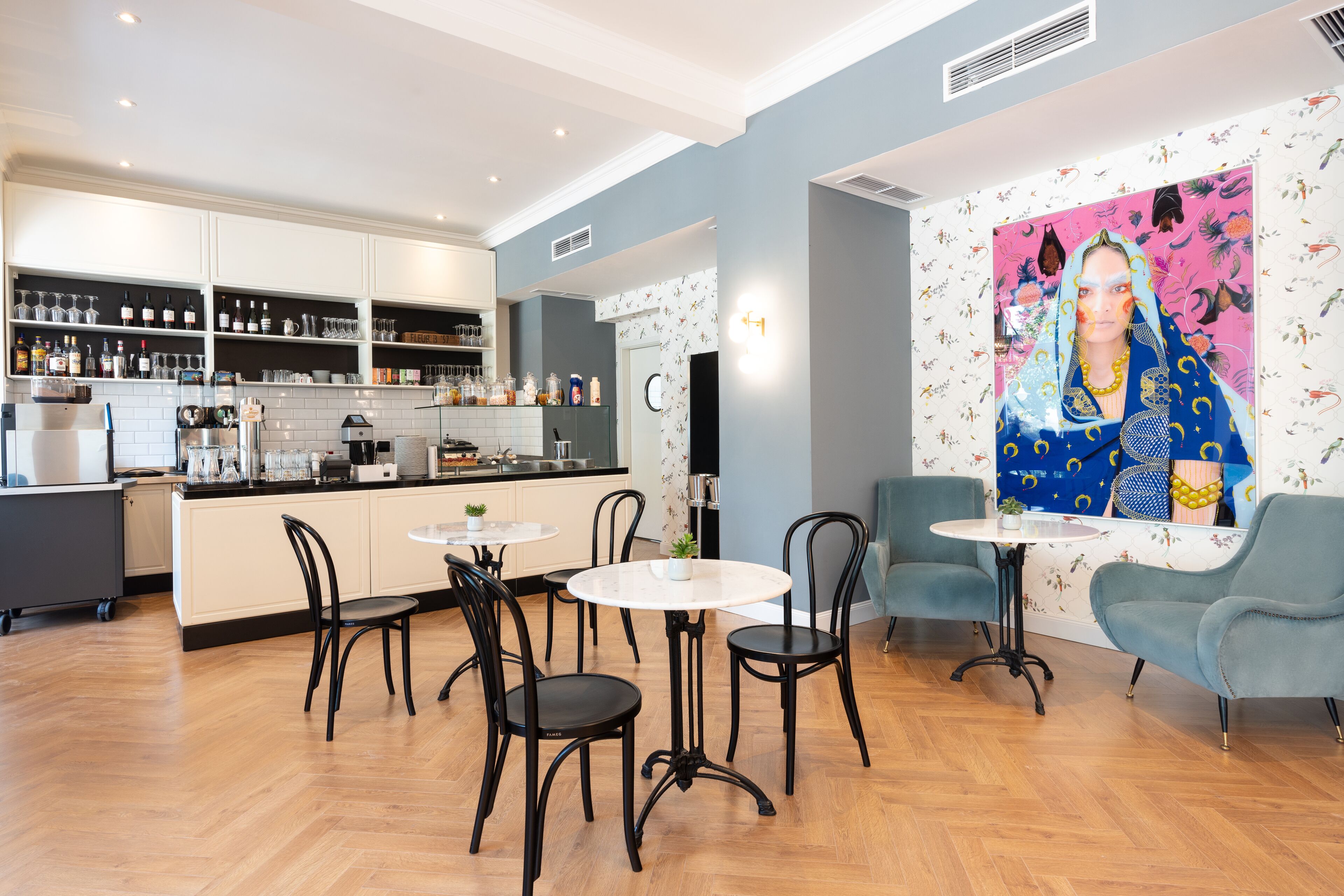 Una cocina moderna con armarios blancos, encimera negra y zona de comedor con mesa y sillas redondas.