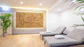 Um quarto de spa com duas cadeiras reclináveis, um painel de parede de madeira e um vaso de planta.