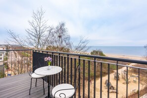 A balcony with a table and chairs, overlooking a beach and a sandy area with playground equipment. - Strandhotel Ahlbeck, a member of Radisson Individuals (Heringsdorf)