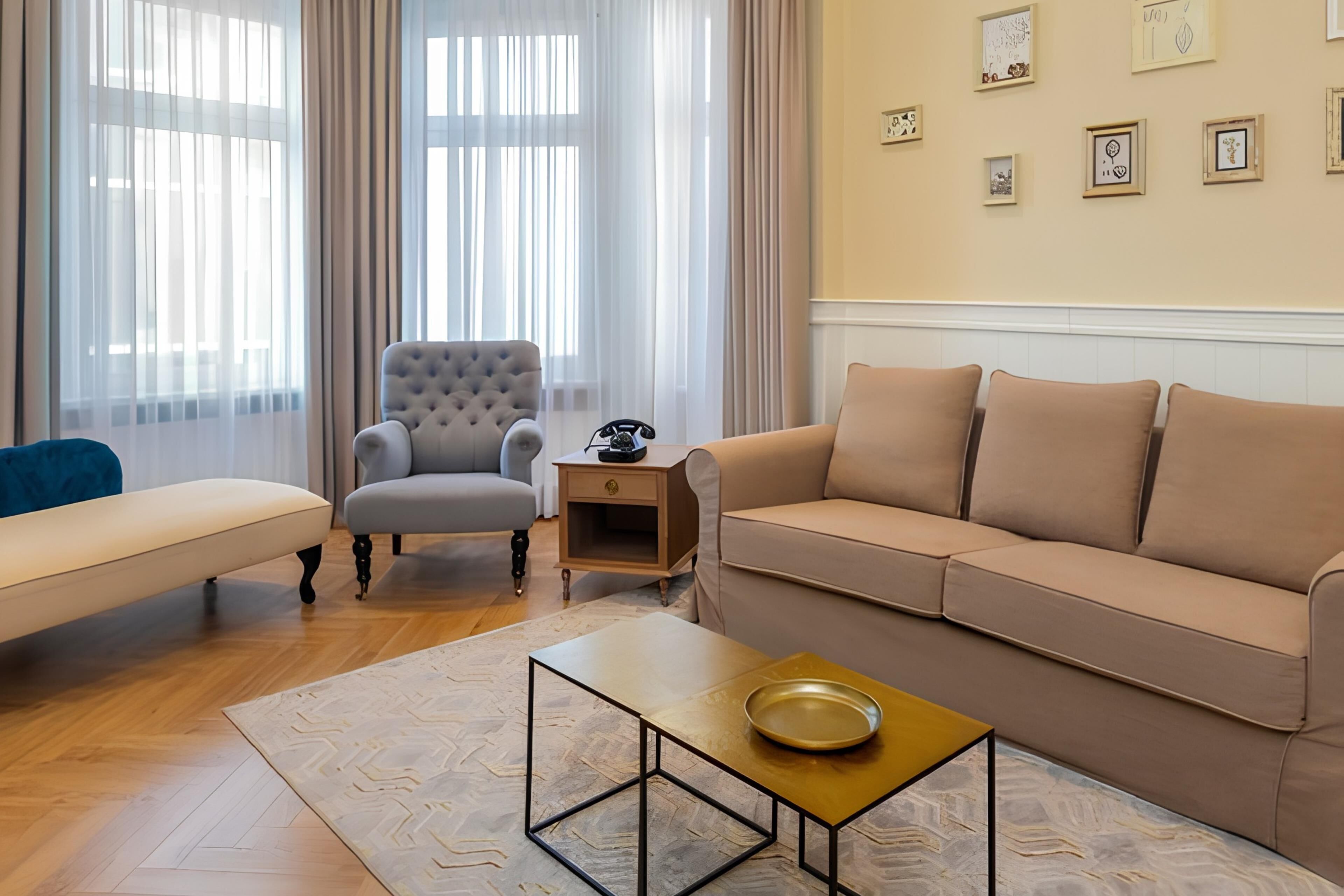 Ein Wohnzimmer mit einer Couch, einem Sessel, einem Couchtisch und einem Beistelltisch mit Telefon.