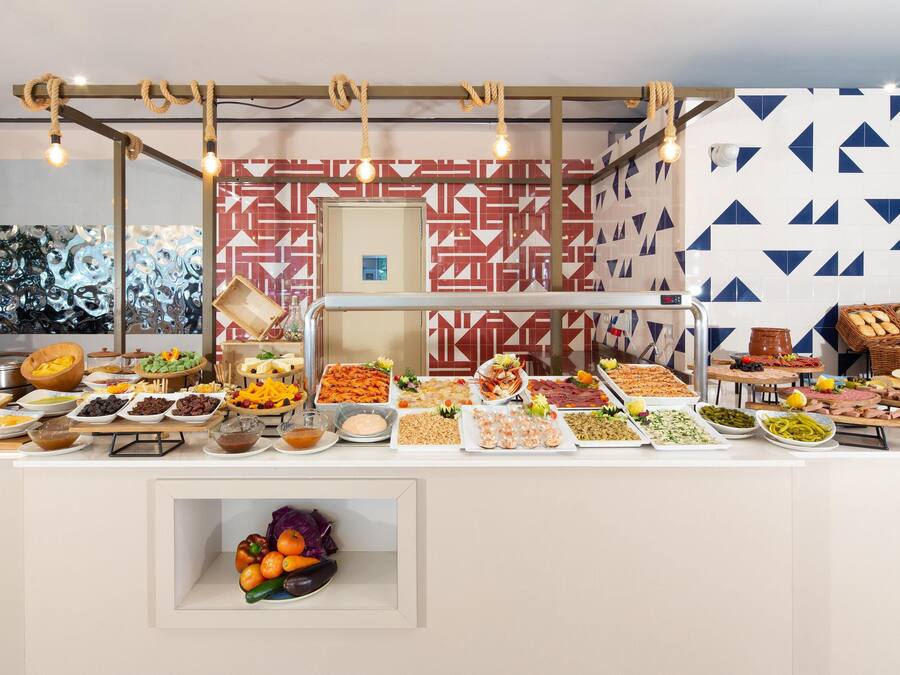 A buffet with various food items and a fruit bowl.