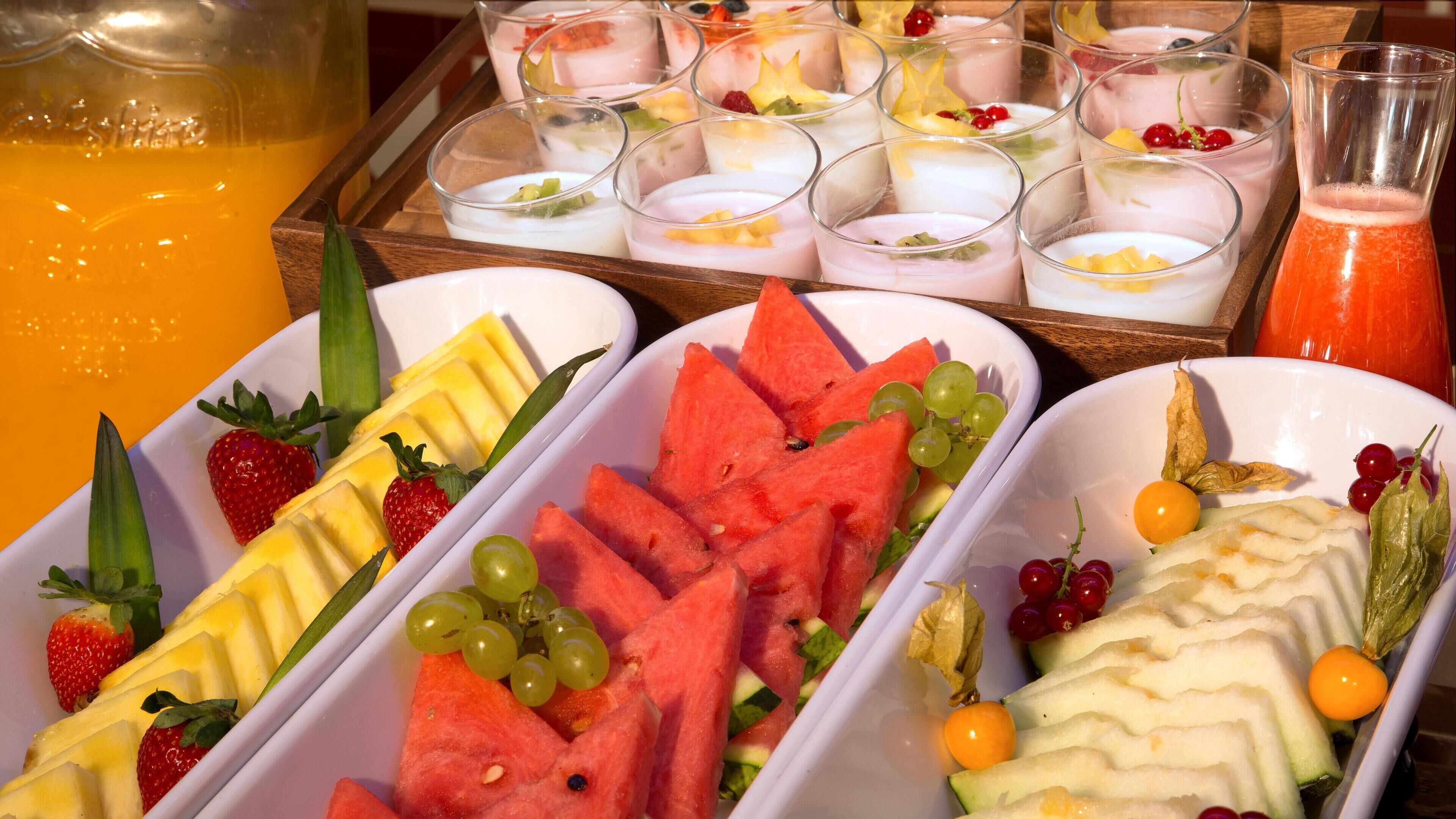 A breakfast buffet with various fruits and beverages.