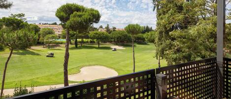 Un campo de golf con una terraza de madera y una mesa con palos de golf.