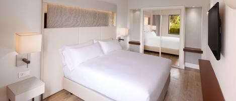 A hotel room with a large bed, bedside lamps, a flat-screen TV, and a view of the outdoors.