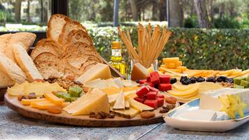 Una tabla de quesos y embutidos con frutas, nueces y pan.