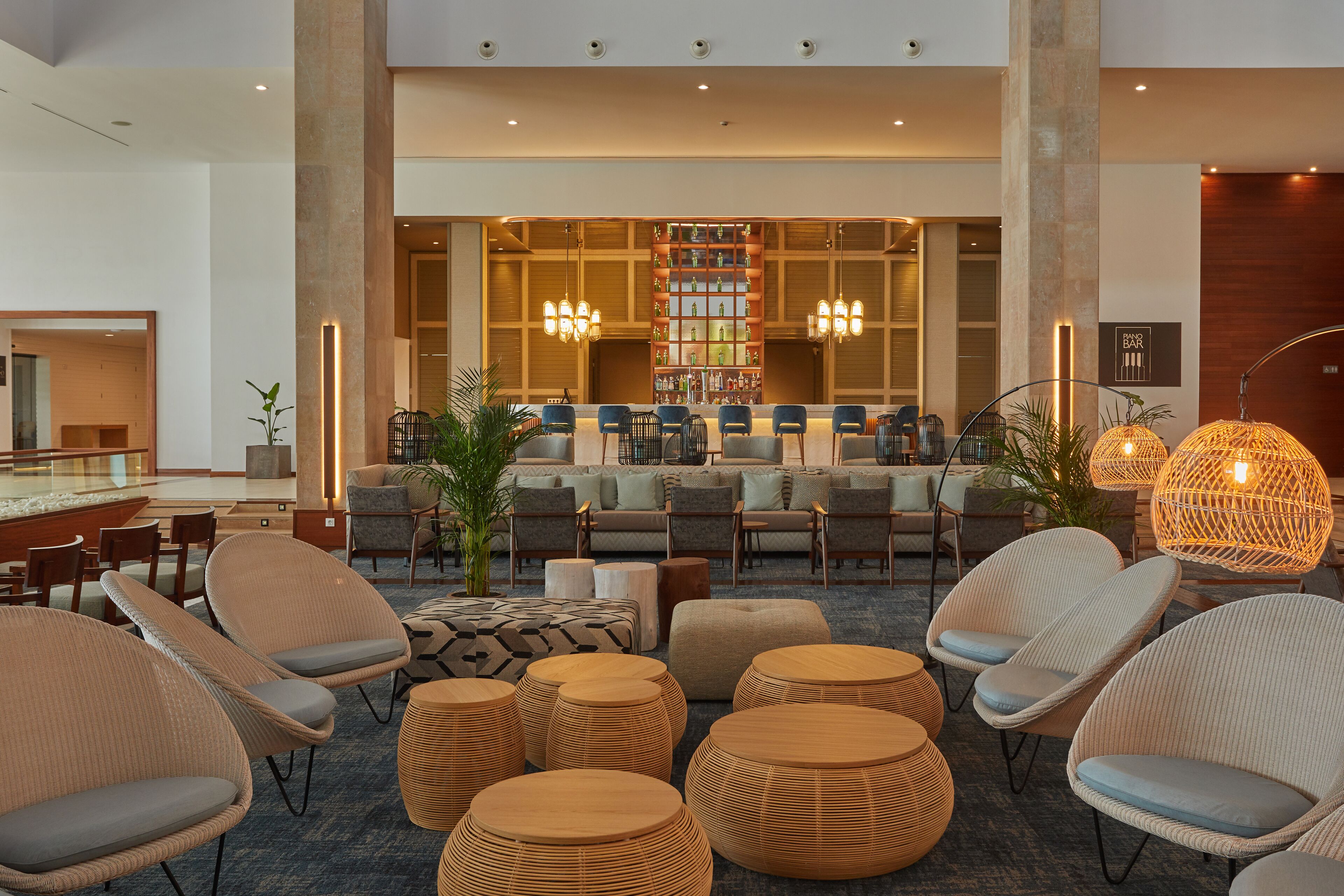 A spacious lobby with comfortable seating, a bar area, and a large bookshelf.