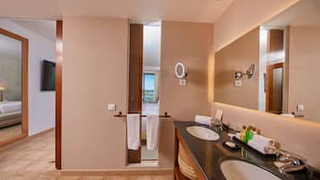 Un baño de hotel con un espejo grande, dos lavamanos y un perchero para toallas.