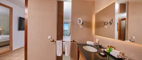 A hotel bathroom with a large mirror, two sinks, and a towel rack.